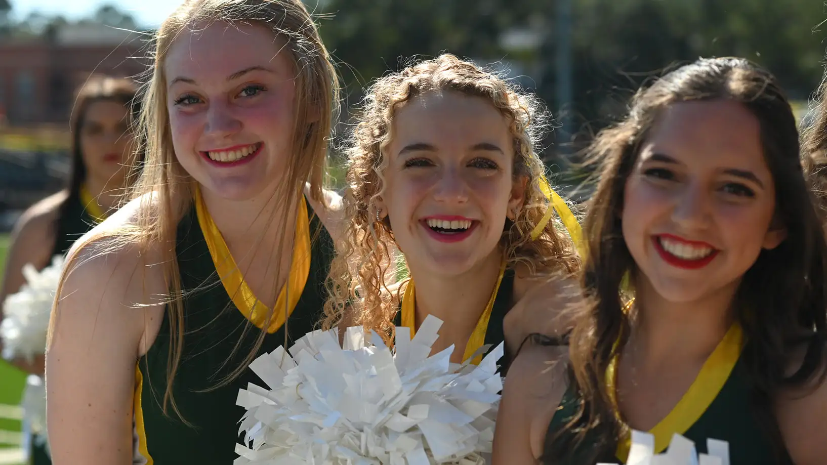 three cheerleaders smiling