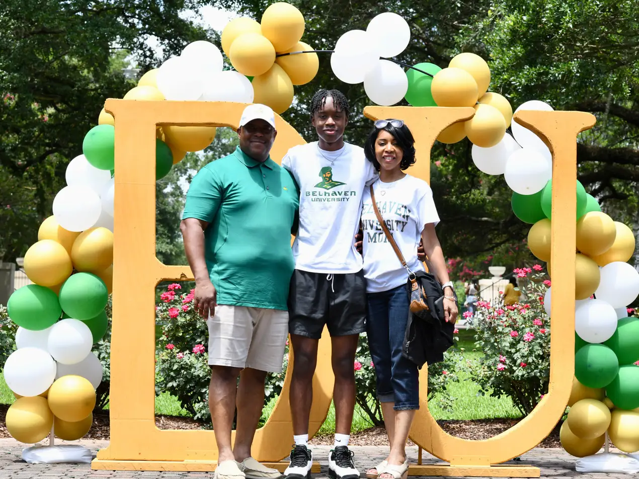 student and family in front of BU sign during welcome week