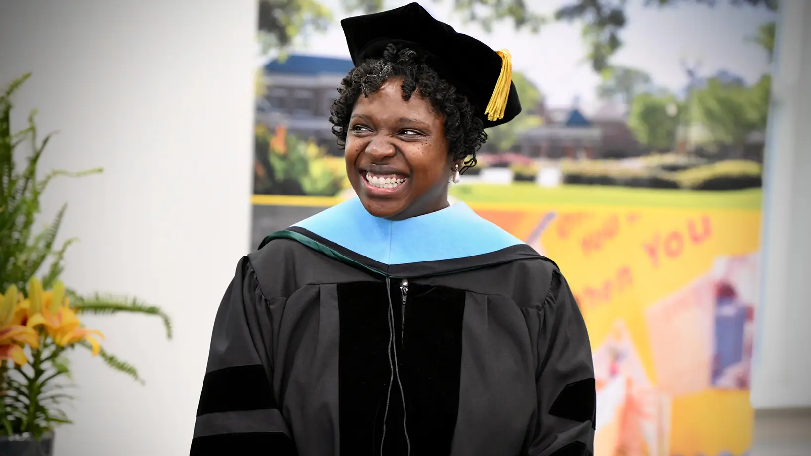 a doctoral student in regalia smiling