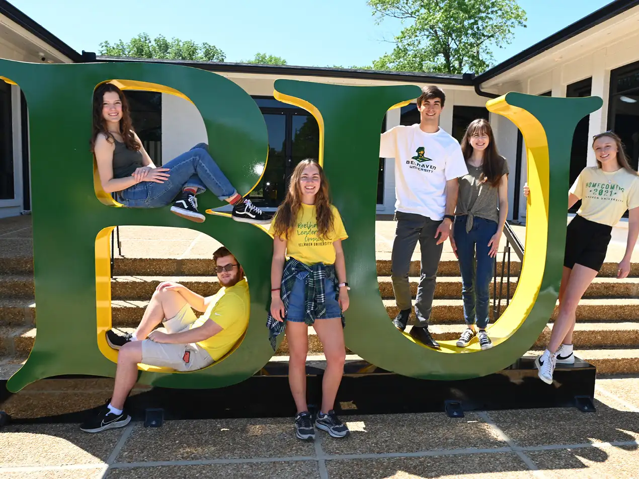 six students on the metal BU sign