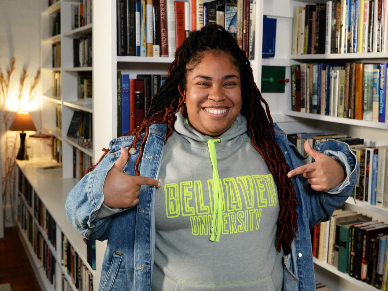 Angie Thomas pointing to the Belhaven shirt she is wearing
