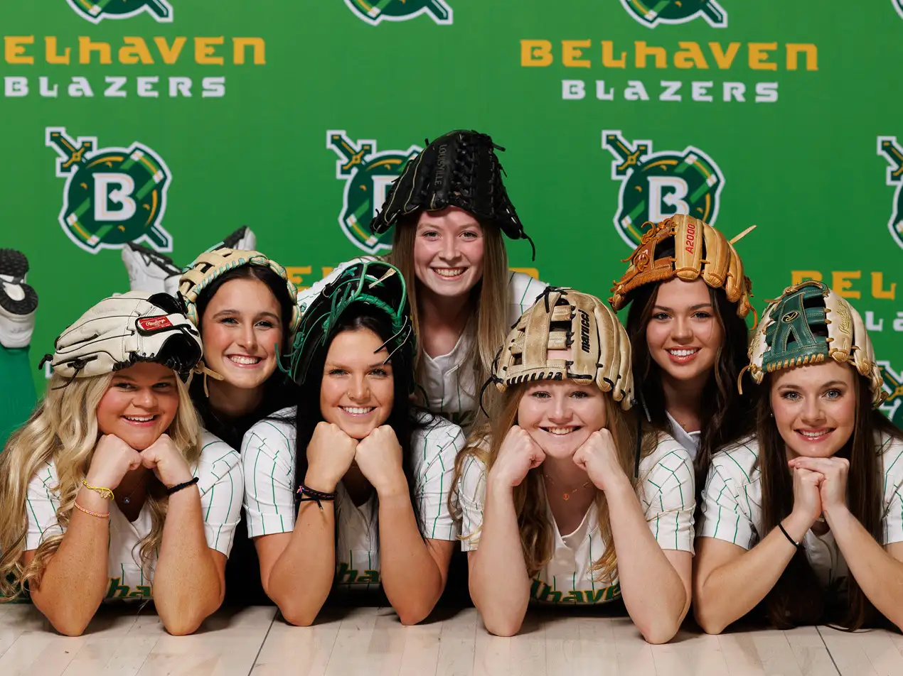 softball players posing with their gloves on their heads
