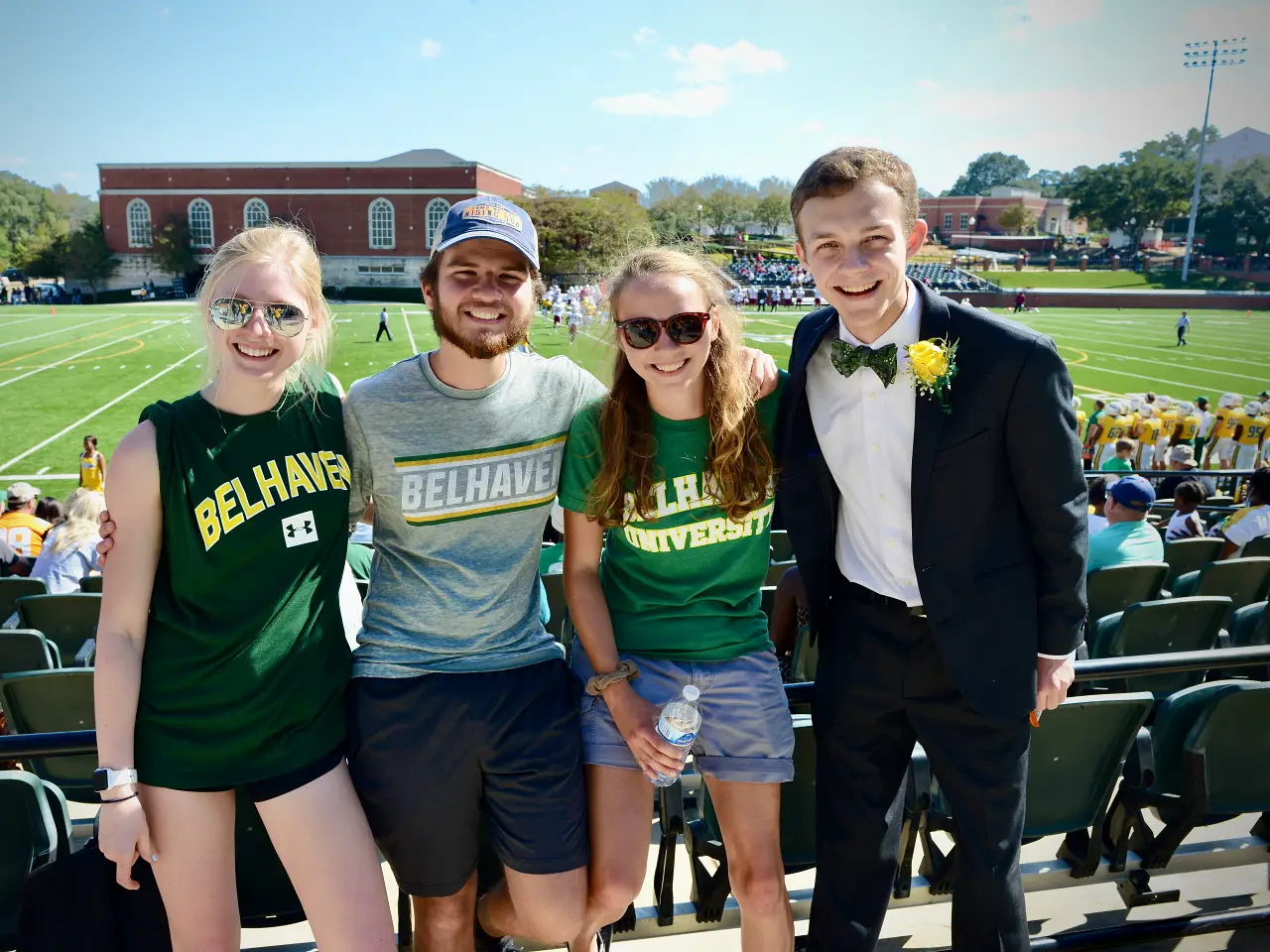 four Belhaven students smiling at a football game