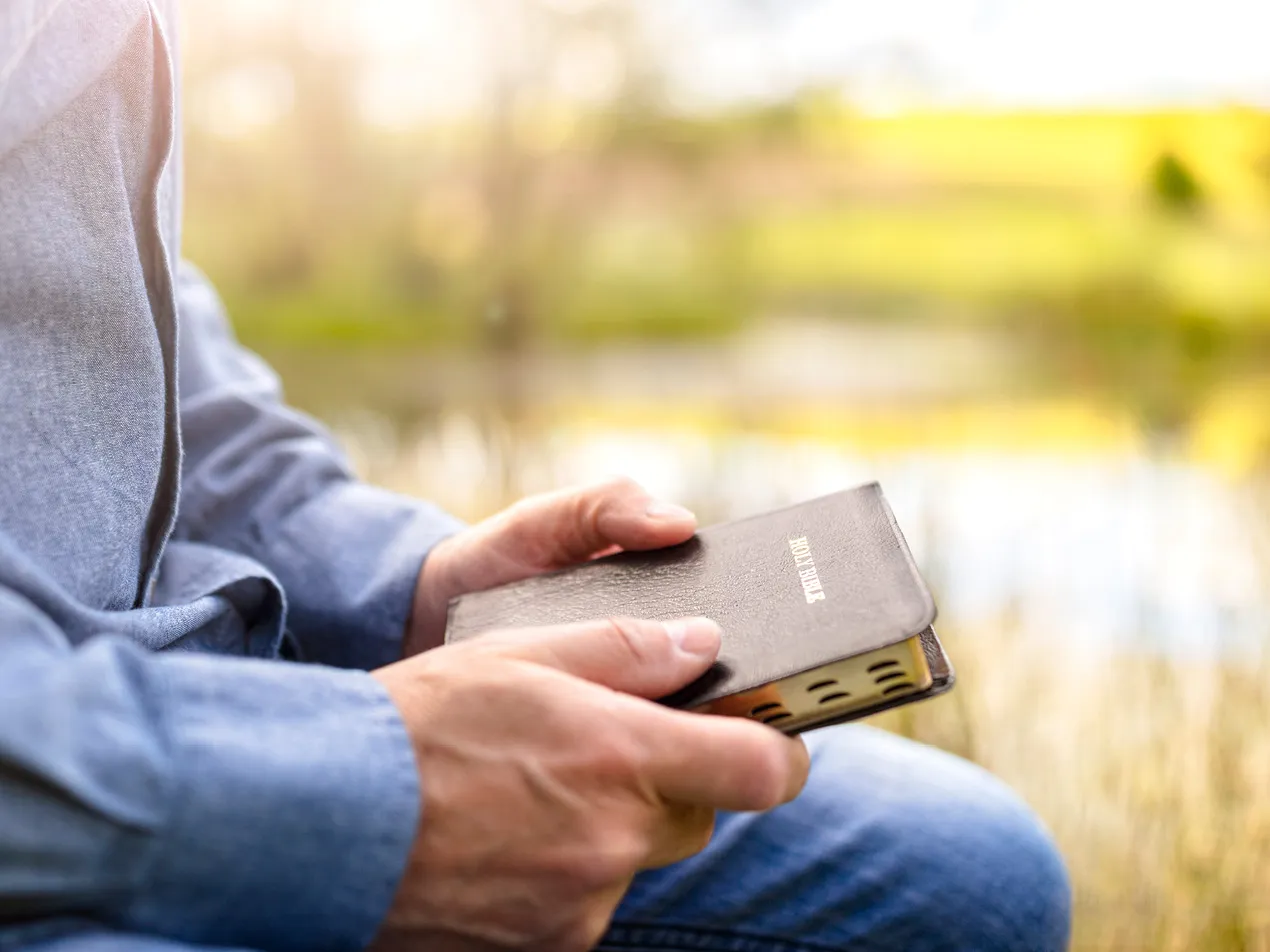 man in field with bible