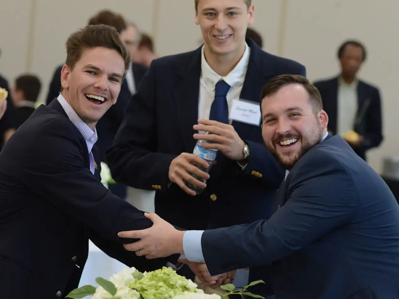 business students in suits smiling