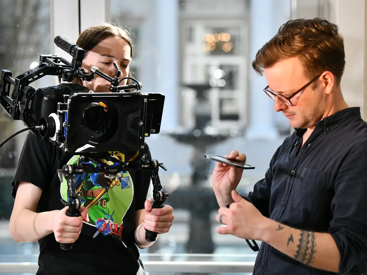 Film production professor teaching a student how to use a camera