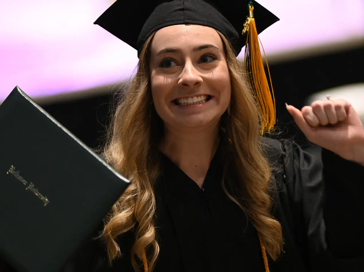happy graduate holding diploma