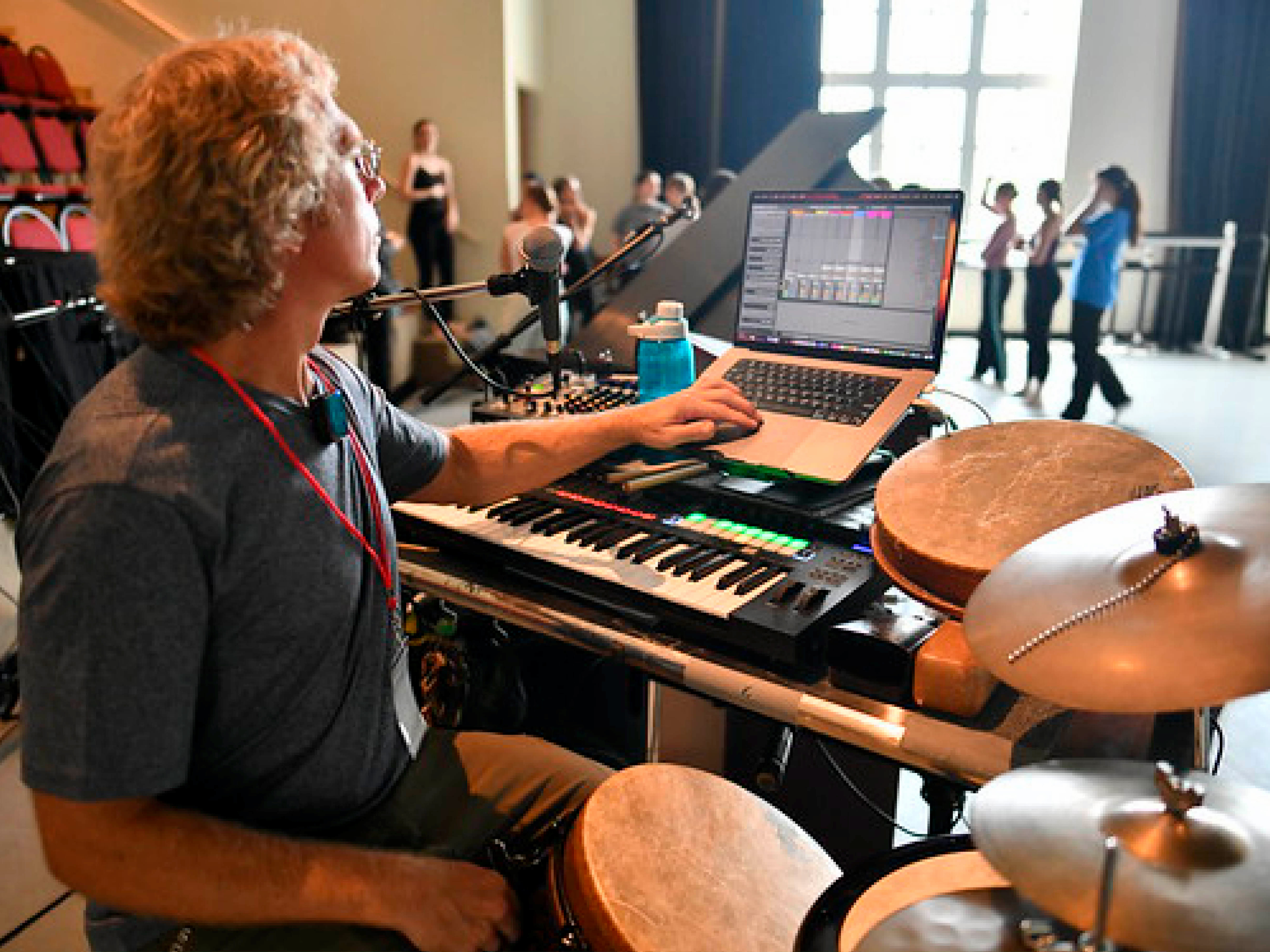 Musician at keyboard and drum set playing for a live dance class