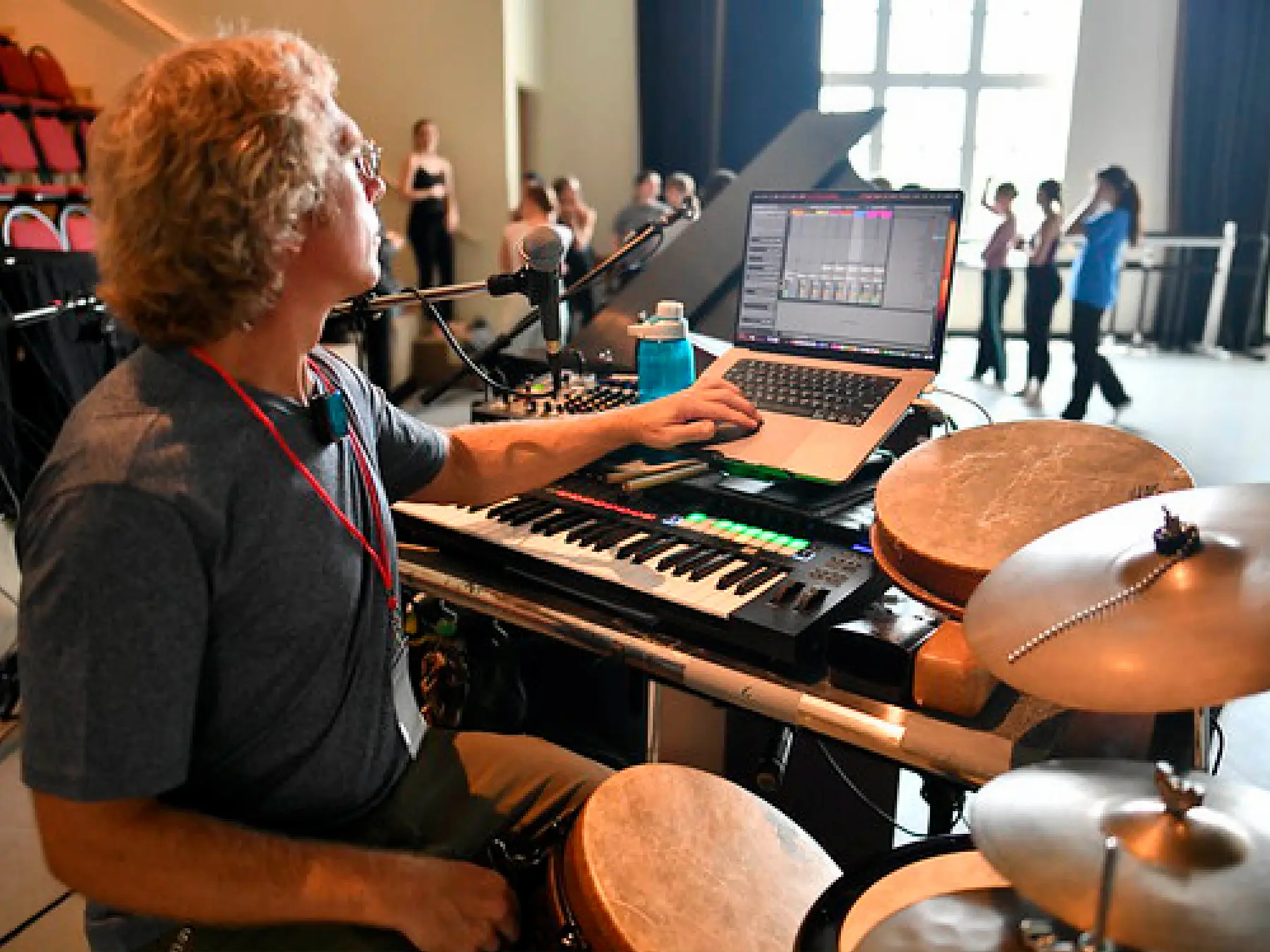 Musician at keyboard and drum set playing for a live dance class
