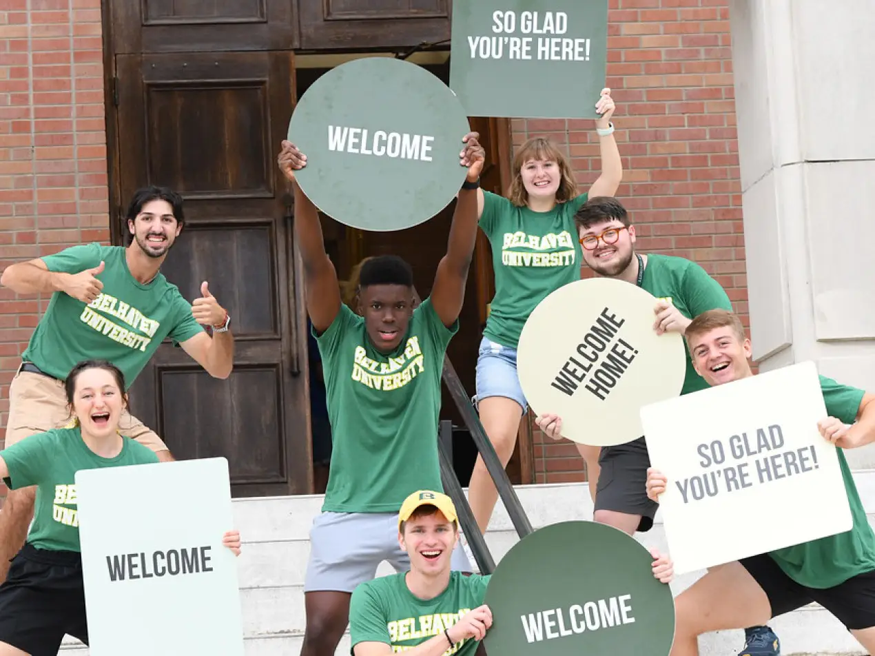 students at welcome week holding welcome signs