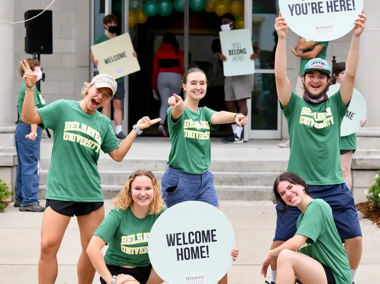students at welcome week holding welcome signs