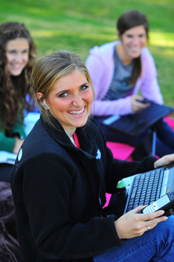 students working on a computer laughing